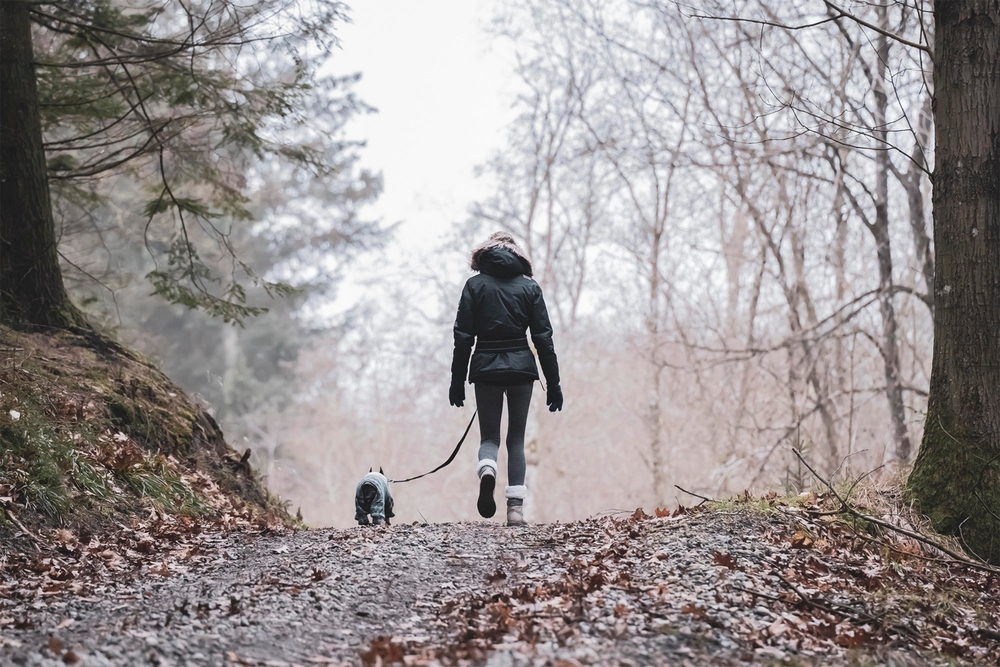 a woman with her dog hiking outdoors